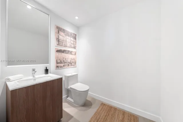 a bathroom with a sink toilet a mirror and vanity