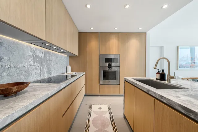 a kitchen with stainless steel appliances granite countertop a sink and a stove