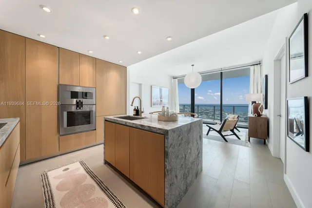 a kitchen with stainless steel appliances granite countertop a stove top oven a sink and a refrigerator