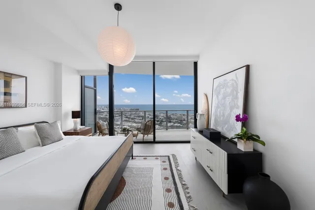 a spacious bedroom with a large bed and a chandelier