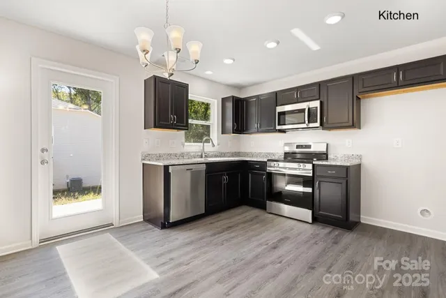 a kitchen with stainless steel appliances granite countertop a stove a sink and a refrigerator