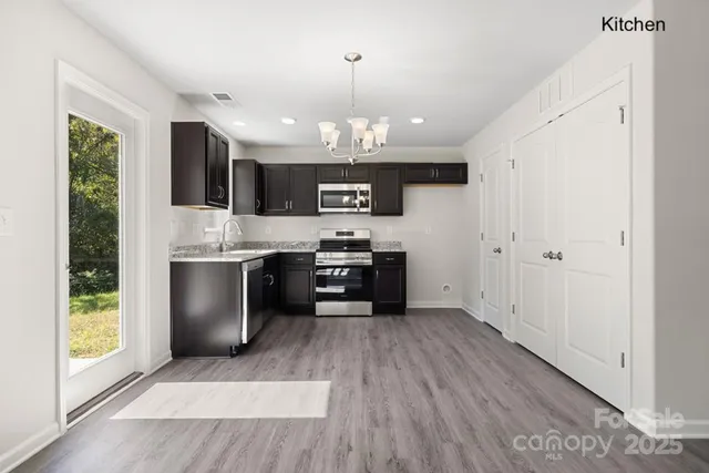 a kitchen with stainless steel appliances granite countertop a stove a sink and a refrigerator