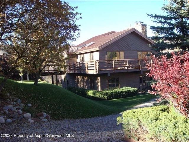 a front view of a house with a garden and plants