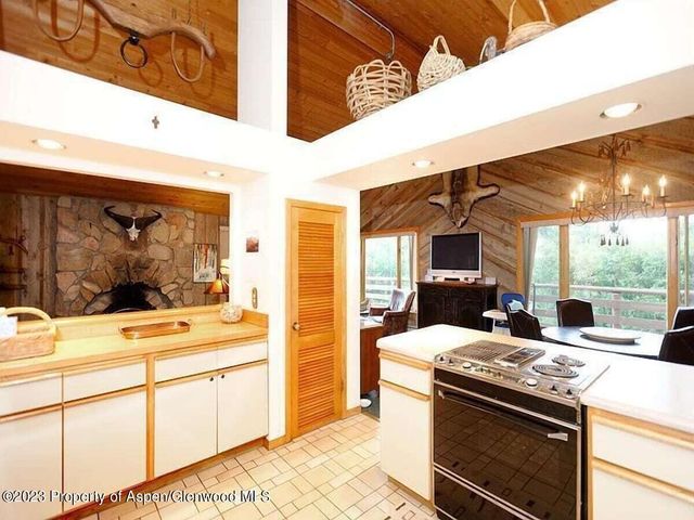 a kitchen with stainless steel appliances kitchen island granite countertop a stove and a view of living room