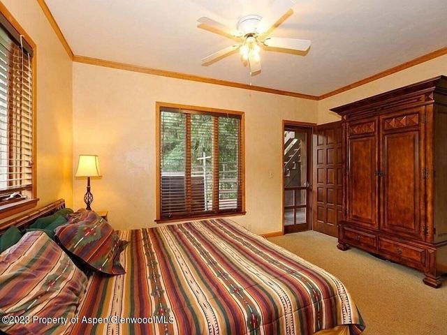 a bed sitting in a spacious bedroom next to a window