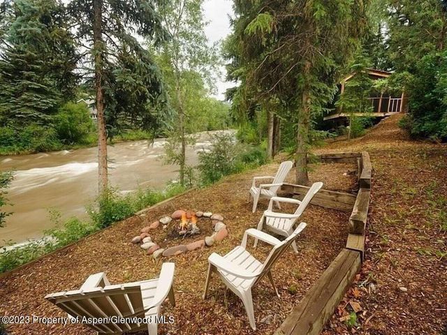 a view of a patio with table and chairs with wooden floor and fence