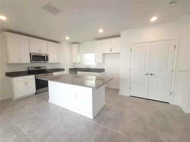 a kitchen with stainless steel appliances granite countertop a sink and a stove