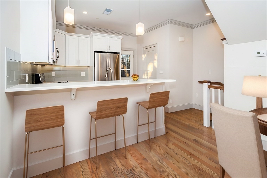53 River Street, Unit 53 Boston, MA 02126 - Photo 1 of 25 a kitchen with stainless steel appliances granite countertop a table chairs sink and cabinets