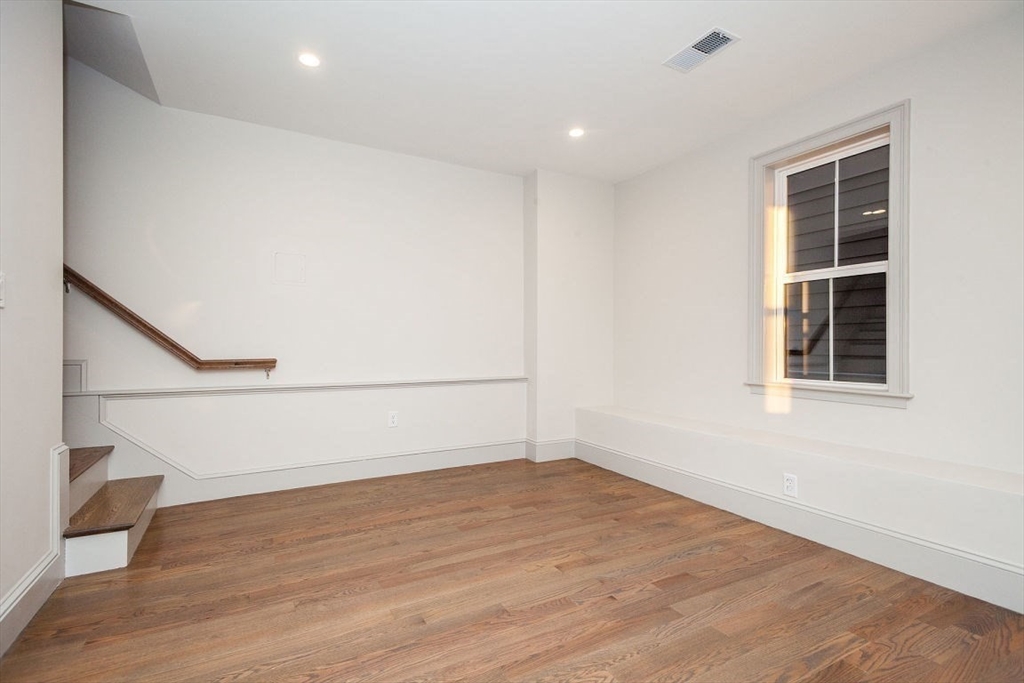 53 River Street, Unit 53 Boston, MA 02126 - Photo 13 of 25 an empty room with wooden floor and windows
