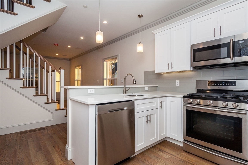 53 River Street, Unit 53 Boston, MA 02126 - Photo 2 of 25 a kitchen with stainless steel appliances granite countertop a stove and a sink