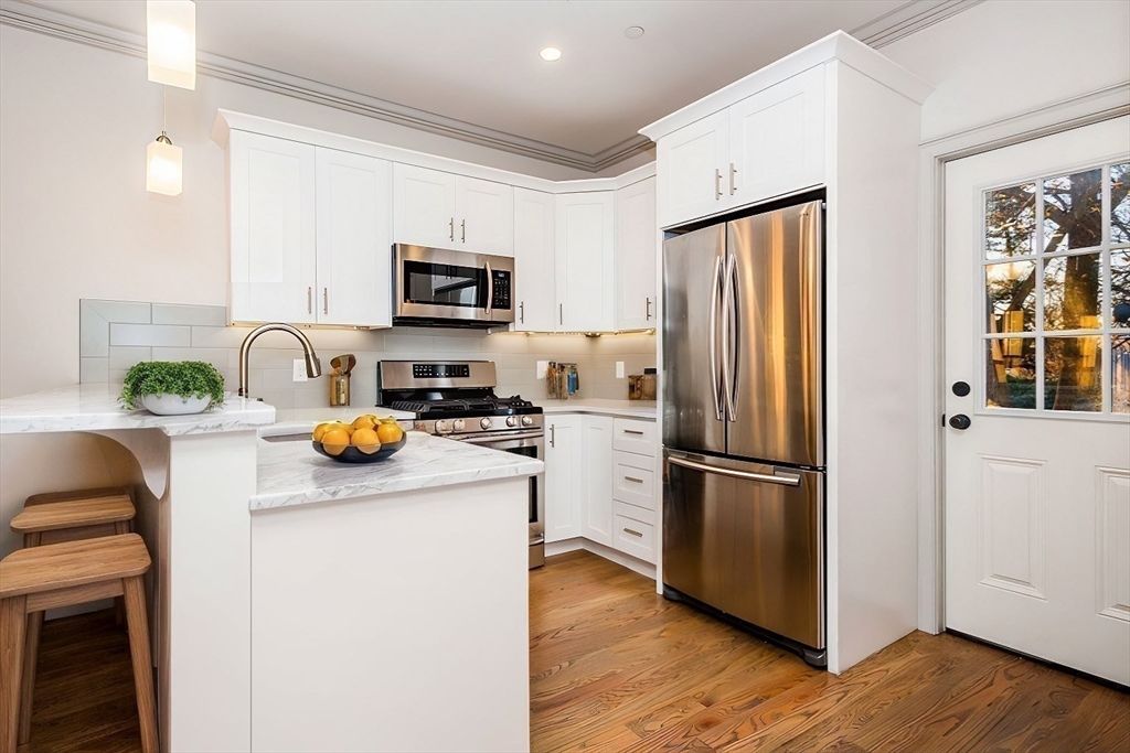 53 River Street, Unit 53 Boston, MA 02126 - Photo 3 of 25 a kitchen with stainless steel appliances granite countertop a refrigerator a stove a microwave and a refrigerator