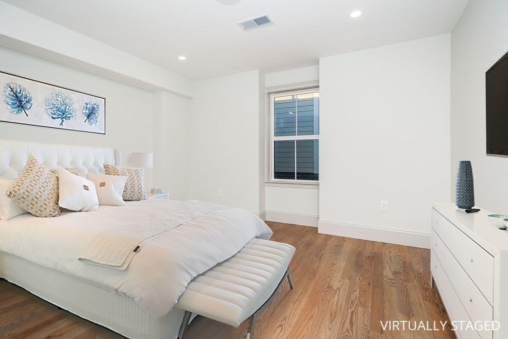 53 River Street, Unit 53 Boston, MA 02126 - Photo 8 of 25 a bedroom with a bed and a flat screen tv