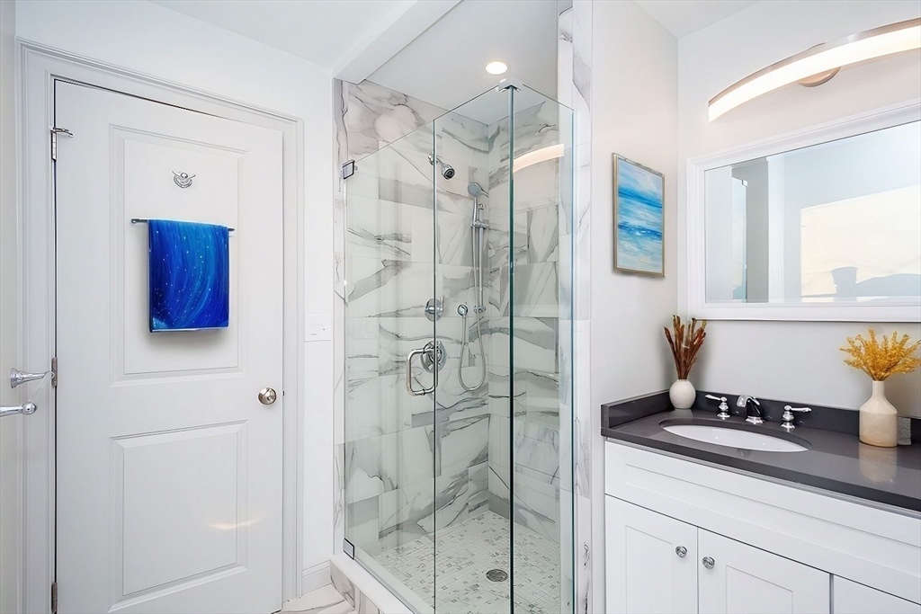 53 River Street, Unit 53 Boston, MA 02126 - Photo 10 of 25 a bathroom with a shower sink and mirror