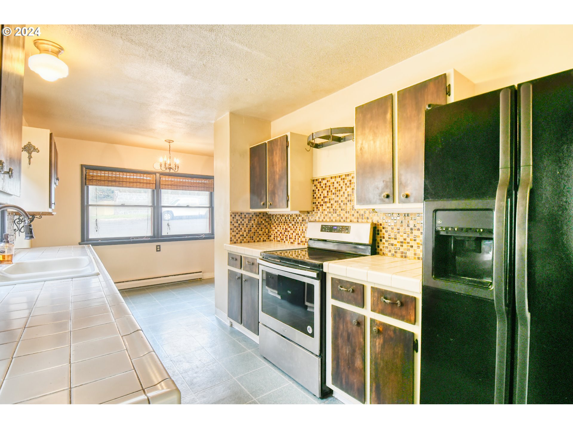 323 North Main Street Pendleton, OR 97801 - Photo 18 of 48 a kitchen with stainless steel appliances kitchen island granite countertop a refrigerator a stove and a sink with granite countertops