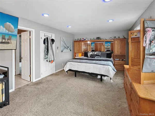 a spacious bedroom with a bed a couch and a chandelier