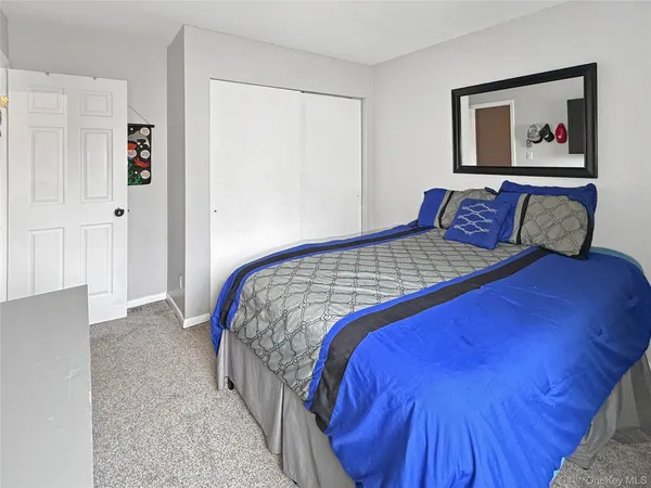a bedroom with a large bed and a painting on the wall