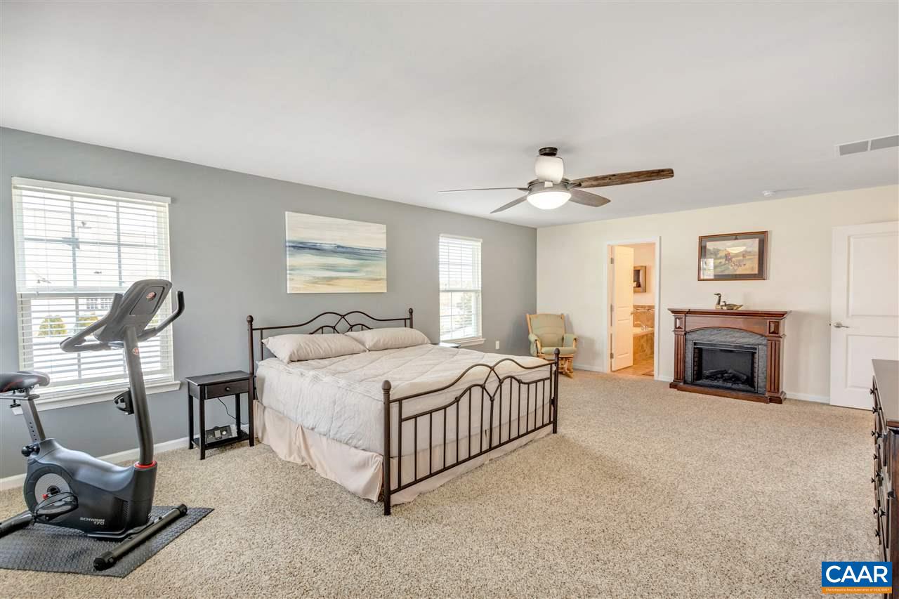 365 Ridgemont Road Ruckersville, VA 22968 - Photo 23 of 50 a spacious bedroom with a bed a table and a fireplace