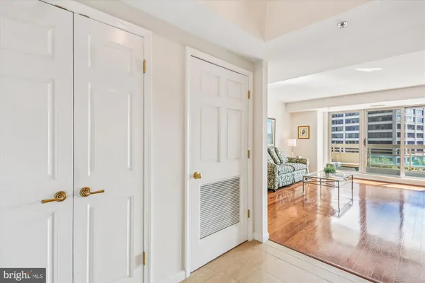 a living room with furniture large window and wooden floor