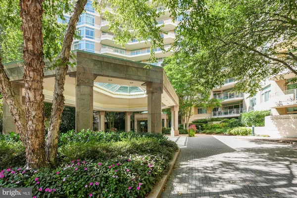 a view of a patio with couches and chairs under an umbrella