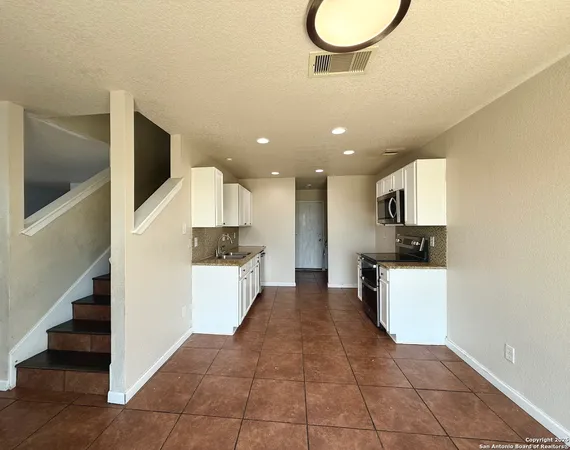 a kitchen with a sink microwave and cabinets