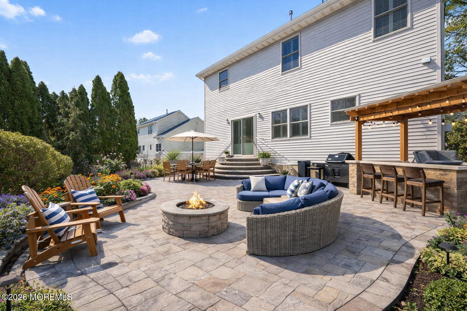 1726 M Street Wall, NJ 07719 - Photo 46 of 49 a view of a patio with dining table and chairs with a fire pit