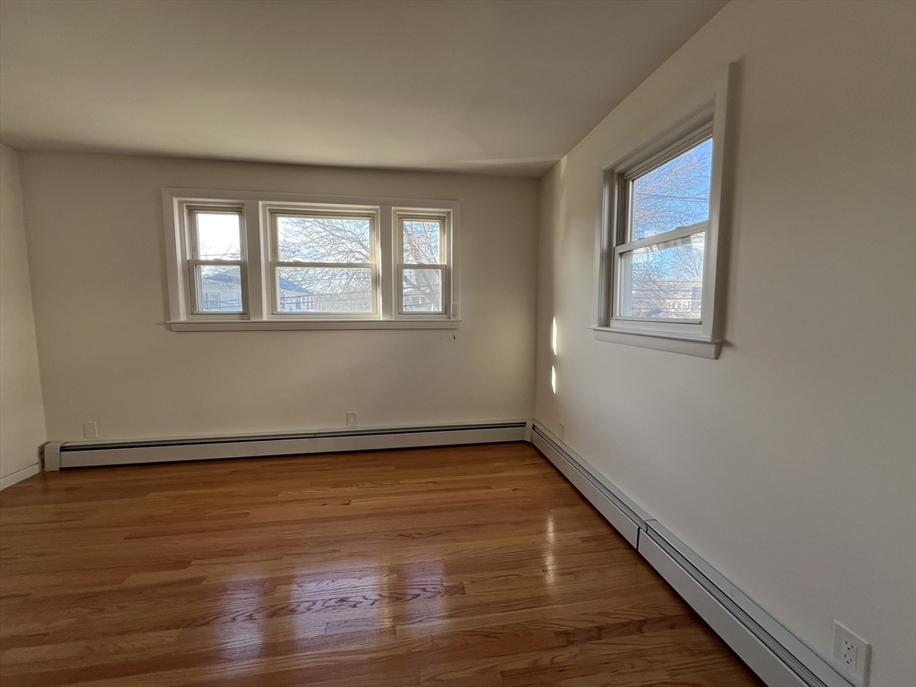 262 Nevada Street, Unit A Newton, MA 02460 - Photo 11 of 34 a view of an empty room with wooden floor and a window