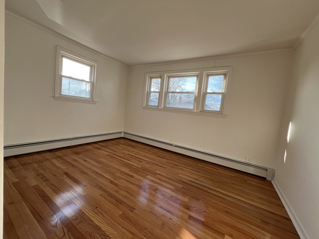 262 Nevada Street, Unit A Newton, MA 02460 - Photo 12 of 34 a view of an empty room with wooden floor and a window