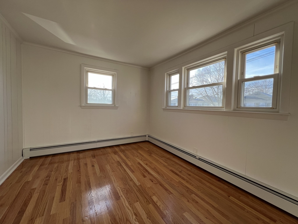 262 Nevada Street, Unit A Newton, MA 02460 - Photo 13 of 34 a view of an empty room with wooden floor and a window