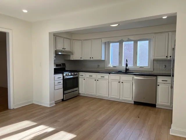 a kitchen with granite countertop white cabinets and white appliances