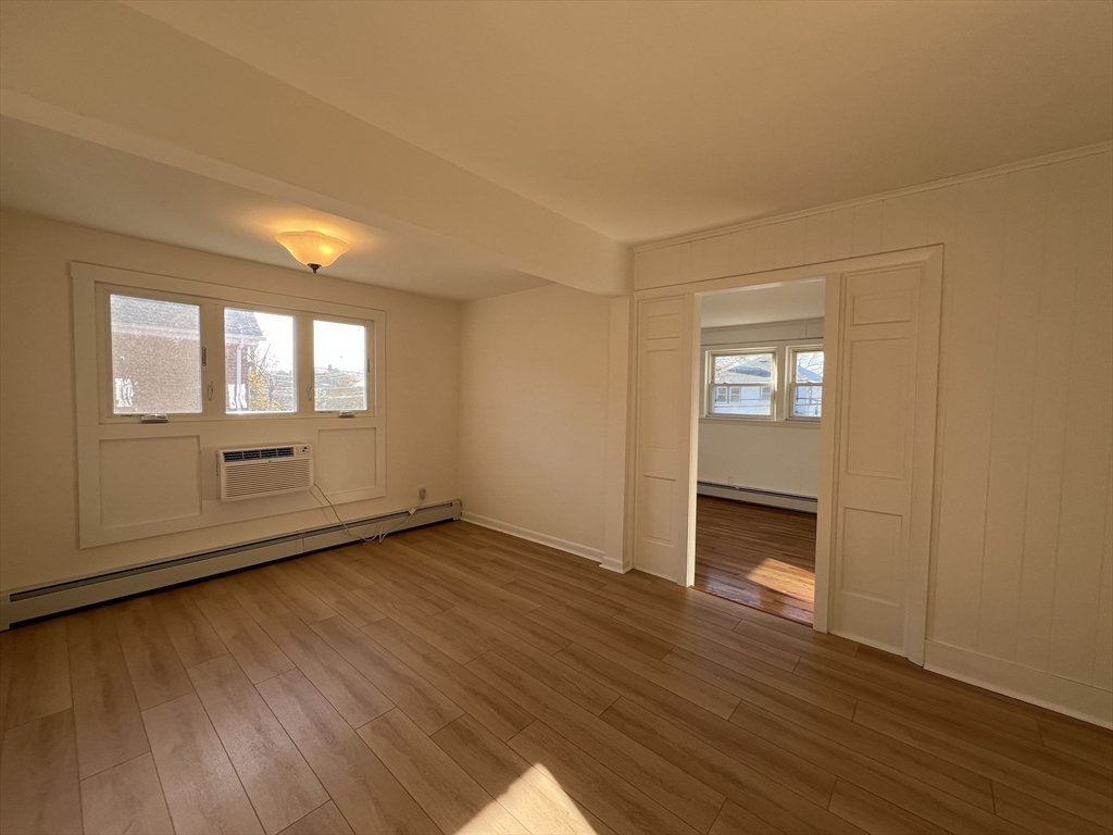 262 Nevada Street, Unit A Newton, MA 02460 - Photo 5 of 34 an empty room with wooden floor and windows