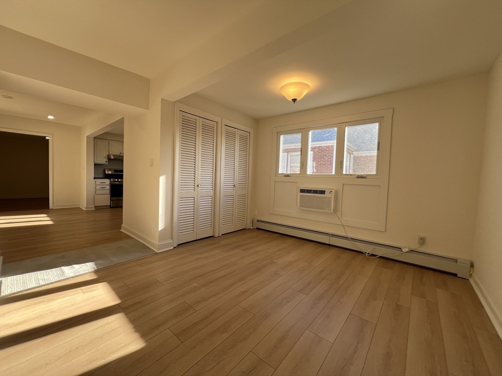 262 Nevada Street, Unit A Newton, MA 02460 - Photo 6 of 34 an empty room with wooden floor and windows