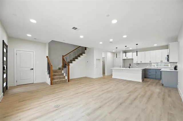 a view of kitchen with kitchen island white cabinets and stainless steel appliances