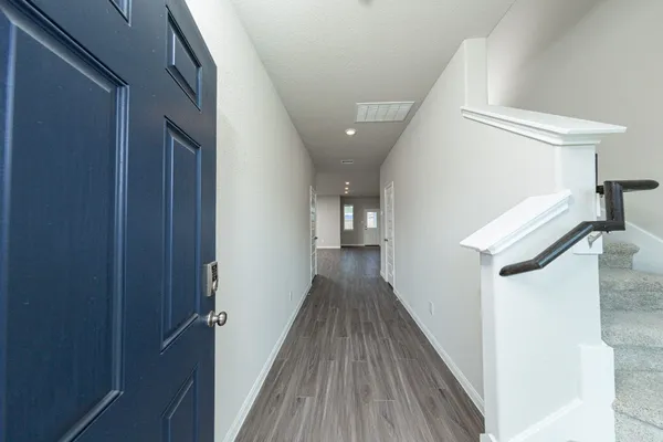 a view of a hallway with wooden floor and staircase