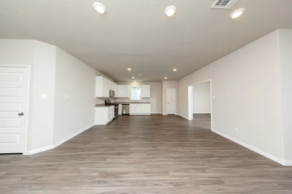 a view of empty room with wooden floor