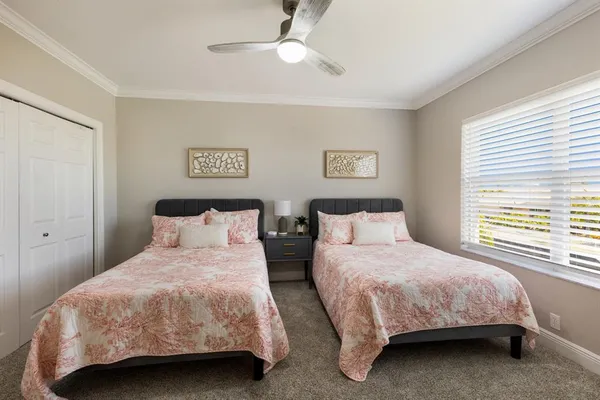 a bedroom with two beds and a chandelier