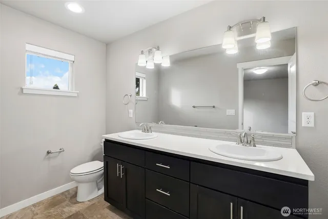 a bathroom with a toilet a sink and mirror