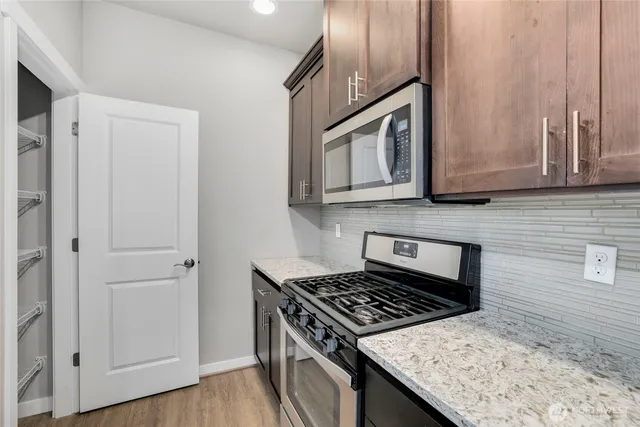 a kitchen with stainless steel appliances granite countertop a stove and a microwave