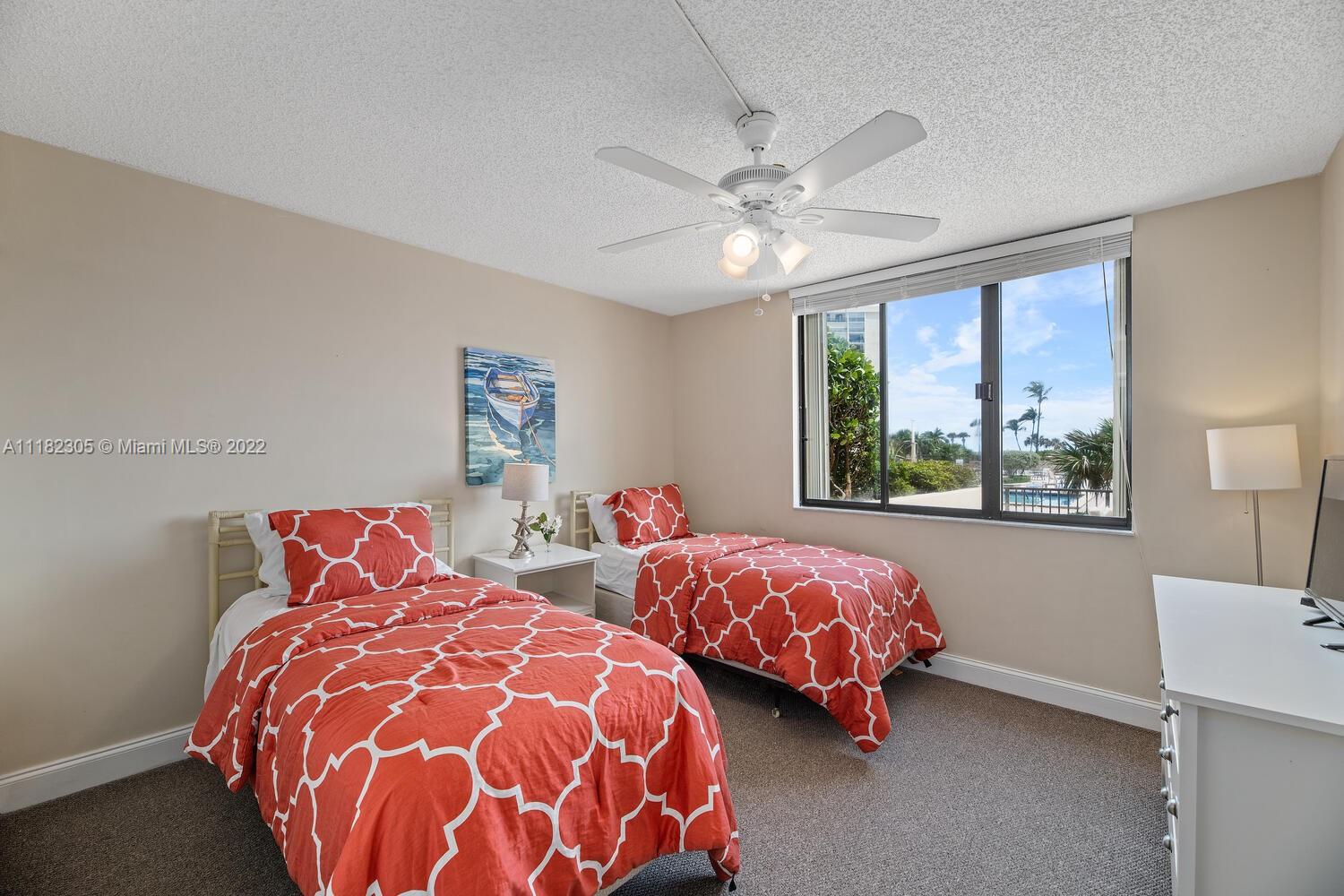300 Ocean Trail Way, Unit 104 Jupiter, FL 33477 - Photo 12 of 26 a bedroom with two beds and a window