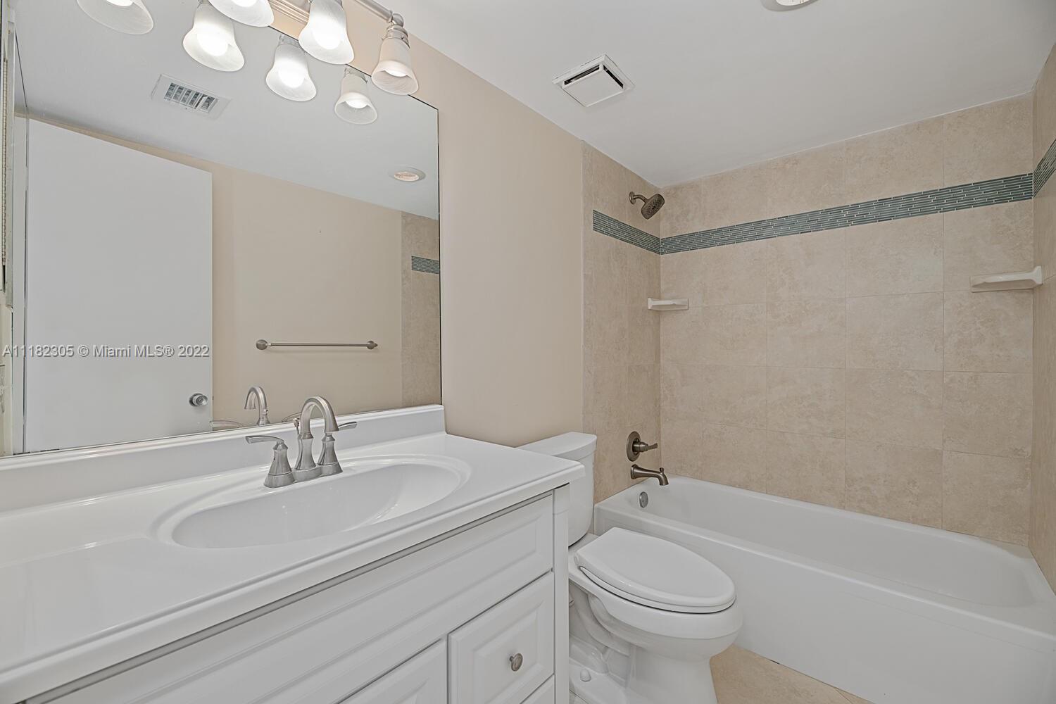 300 Ocean Trail Way, Unit 104 Jupiter, FL 33477 - Photo 13 of 26 a bathroom with a sink a toilet and a mirror
