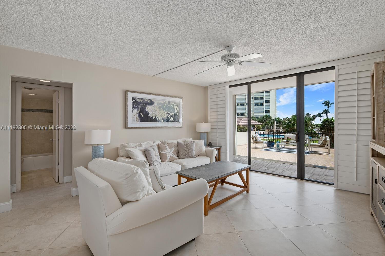 300 Ocean Trail Way, Unit 104 Jupiter, FL 33477 - Photo 3 of 26 a living room with furniture and a large window