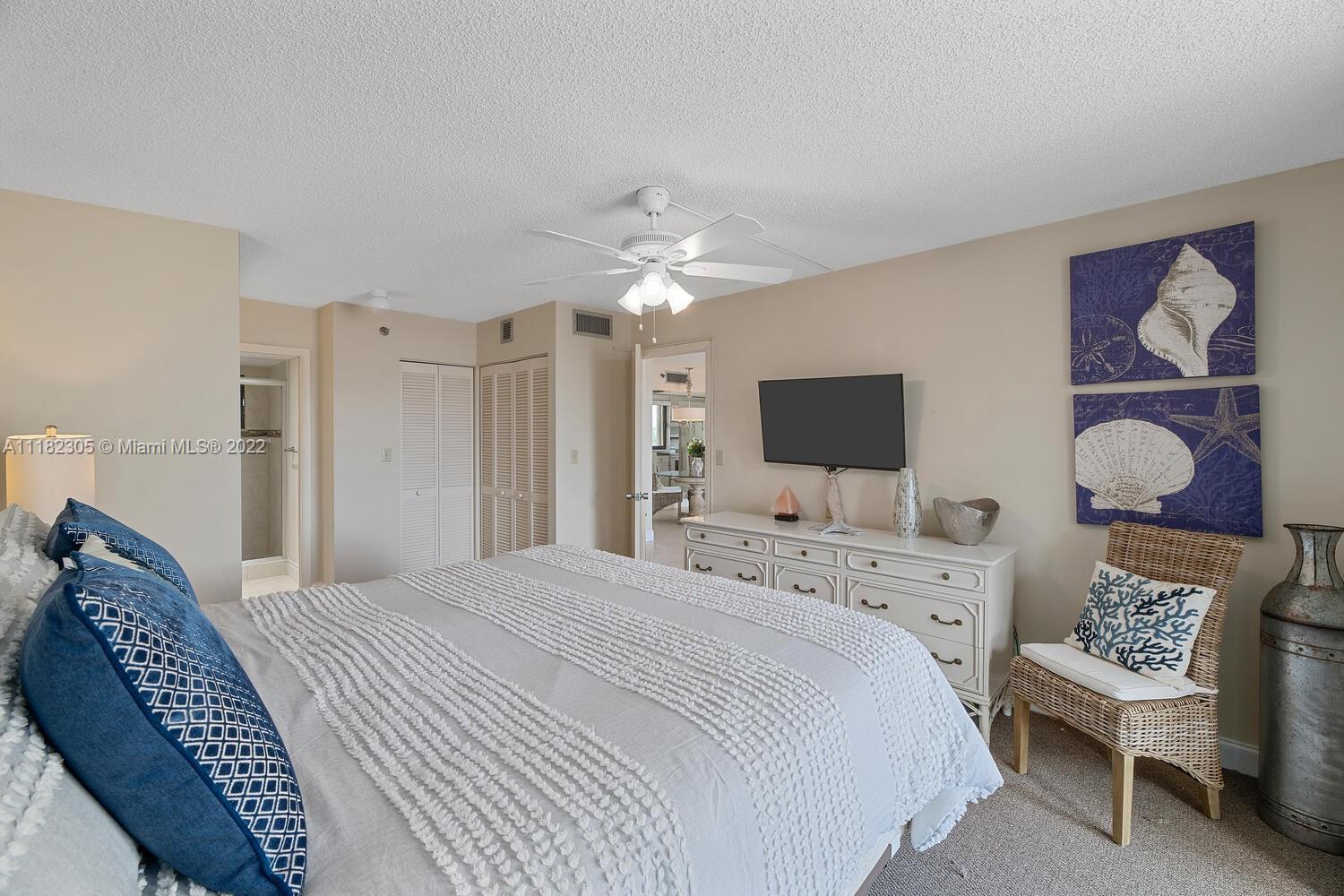 300 Ocean Trail Way, Unit 104 Jupiter, FL 33477 - Photo 10 of 26 a bedroom with a bed a flat screen tv and a couch