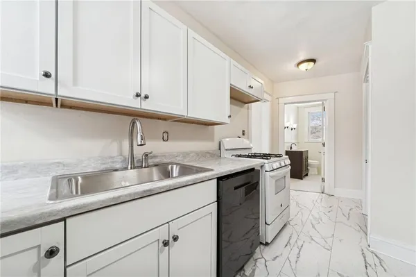 a kitchen with stainless steel appliances granite countertop a sink stove and cabinets
