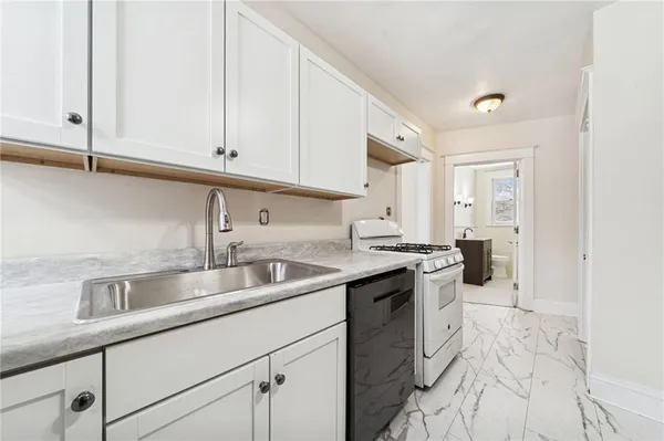 a kitchen with stainless steel appliances granite countertop a sink stove and cabinets