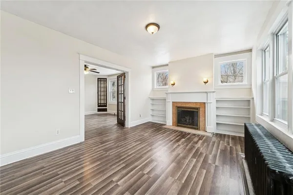 a view of a livingroom with wooden floor and a fireplace
