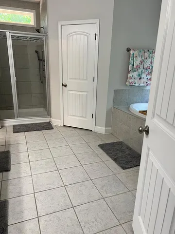 a view of a refrigerator in kitchen and an empty room in wooden floor