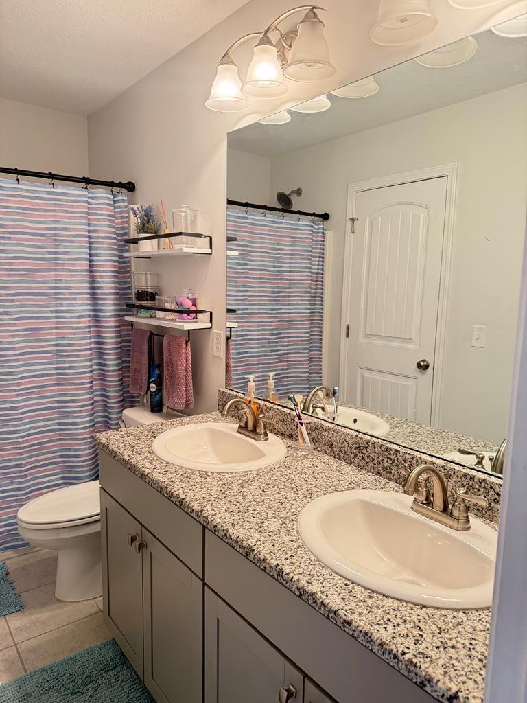 1048 Crosswinds Drive Midland, GA 31820 - Photo 20 of 25 a bathroom with a granite countertop double vanity sink mirror and toilet
