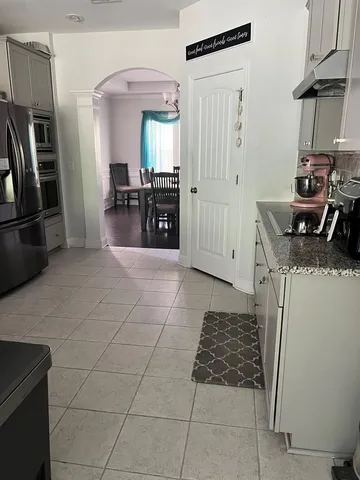a kitchen with granite countertop a stove a refrigerator and cabinets