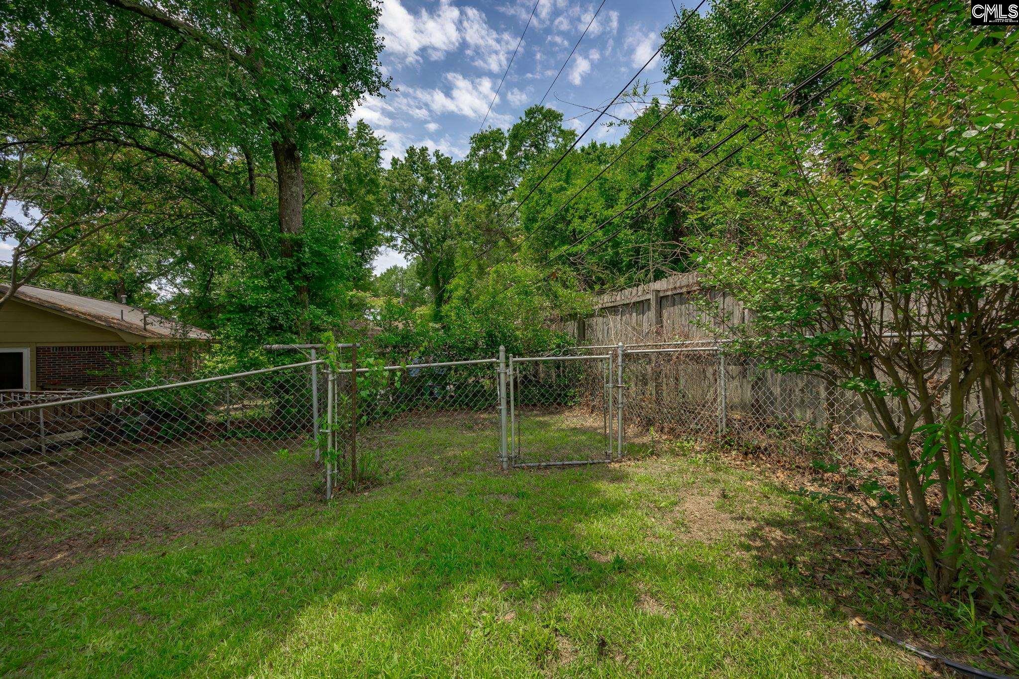 5666 Middleton Court Columbia, SC 29203 - Photo 41 of 42 a backyard of a house with plants and large trees