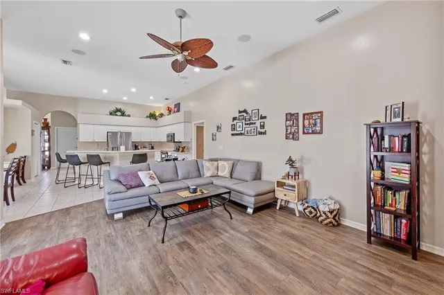 a living room with furniture kitchen view and a book shelf