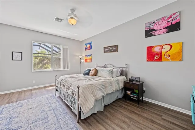 a bedroom with a bed and painting on the wall